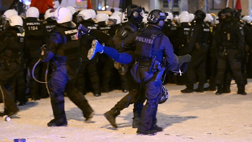 Poliisi kantaa mielenosoittajaa itsenäisyyspäivänä Töölöntorilla.