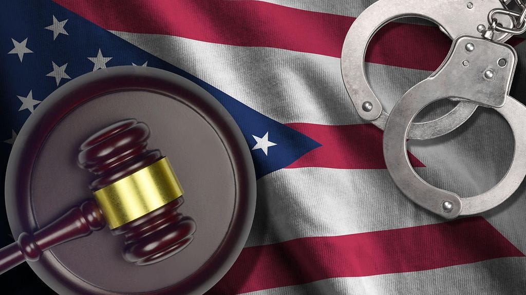 Kuvituskuva. Ohion Yhdysvaltain osavaltion lippu, tuomarin vasara ja käsiraudat.