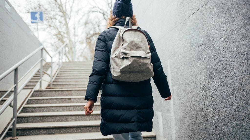 nainen nousee ulkona portaita