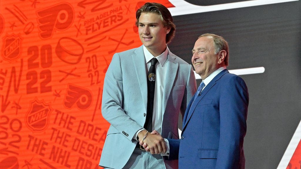 Cutter Gauthier (vas.) kätteli NHL:n komissaarina toimivaa Gary Bettmania kesän 2022 varaustilaisuudessa.