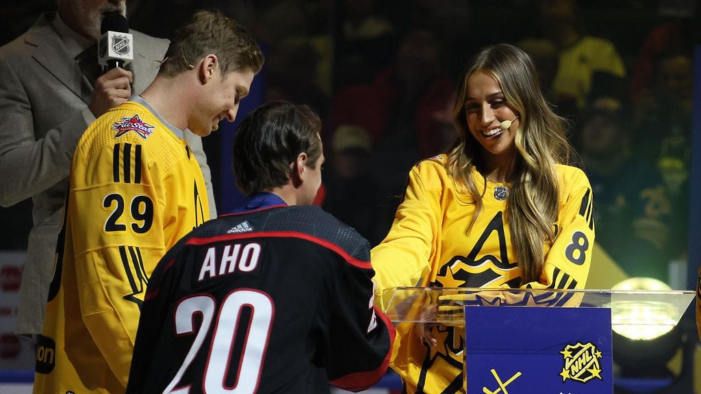 Nathan MacKinnon (vas.) valitsi Sebastian Ahon joukkueeseensa. Laulaja Tate McRae (oik.) esitteli Ahon tapahtuman yleisölle.