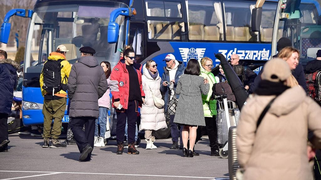 Ryhmä venäläisiä turisteja valmistautuu nousemaan linja-autoihin sen jälkeen, kun he ovat saapuneet Pjongjangin kansainväliselle lentokentälle Pjongjangissa tänään perjantaina.