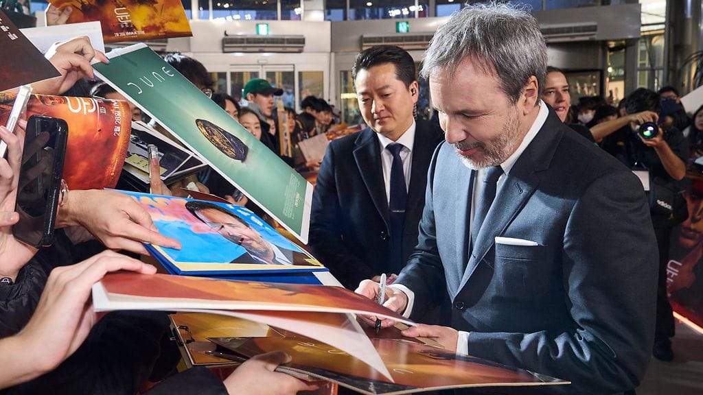 Menestysohjaaja Denis Villeneuve jakaa nimikirjoituksia faneille.