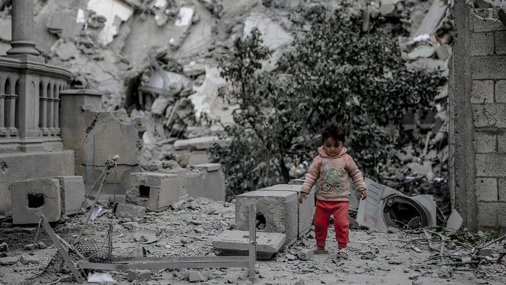 Palestiinalaislapsi kävelee pommituksissa tuhoutuneiden talojen raunioilla Gazan kaupungissa 3. maaliskuuta 2024.