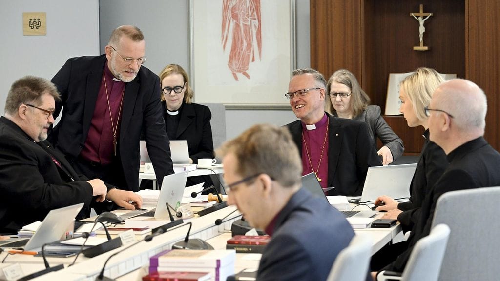 LK 10.4.2024 Kuopion hiippakunnan piispa Jari Jolkkonen (seisoo vas.) ja arkkipiispa Tapio Luoma (pöydän päässä) Suomen evankelis-luterilaisen kirkon piispainkokouksessa Helsingissä 10. huhtikuuta 2024.