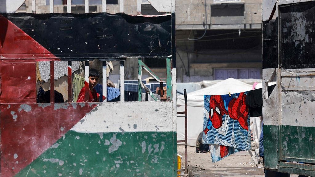 Lapsi katselee portin takaa siirtymään joutuneiden palestiinalaisten leirillä Rafahissa Gazan eteläosassa 19. huhtikuuta.