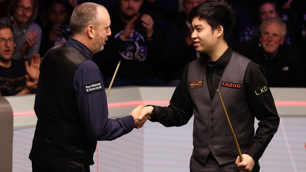 Mark Williams (vas.) onnitteli lähes 28 vuotta nuorempaa vastustajaansa Si Jiahuita voitosta MM-snookerissa tiistaina.