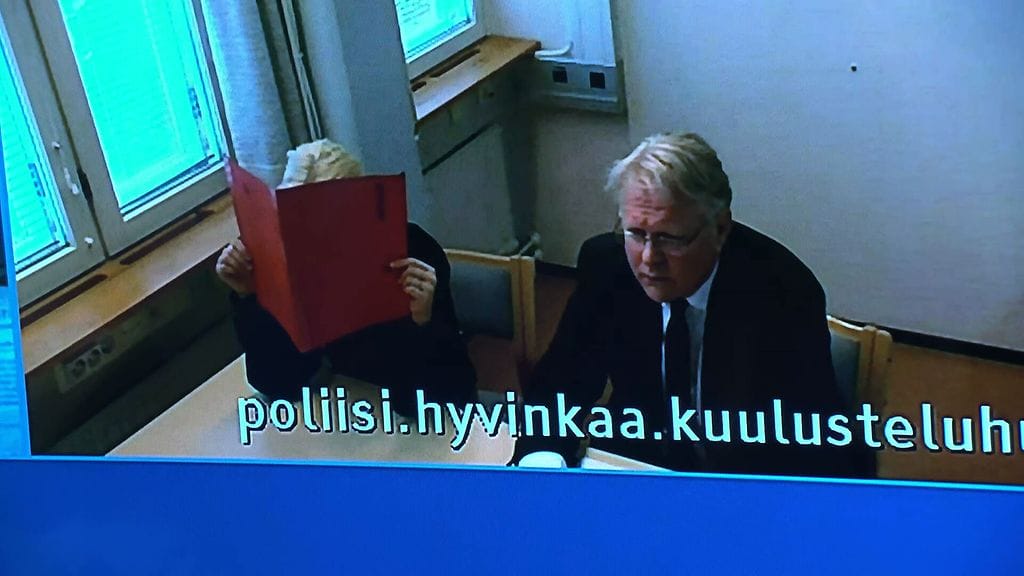 21-vuotias nainen peitti kasvonsa Itä-Uudenmaan käräjäoikeuden vangitsemiskäsittelyssä, johon hän osallistui etäyhteydellä. Naisen vieressä on hänen avustajansa.