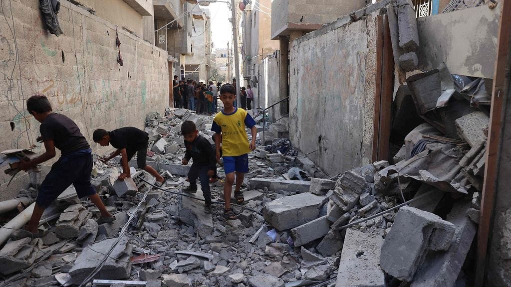 Palestiinalaislapsia kävelemässä raunioissa Rafahissa Gazan eteläosassa 7. toukokuuta.