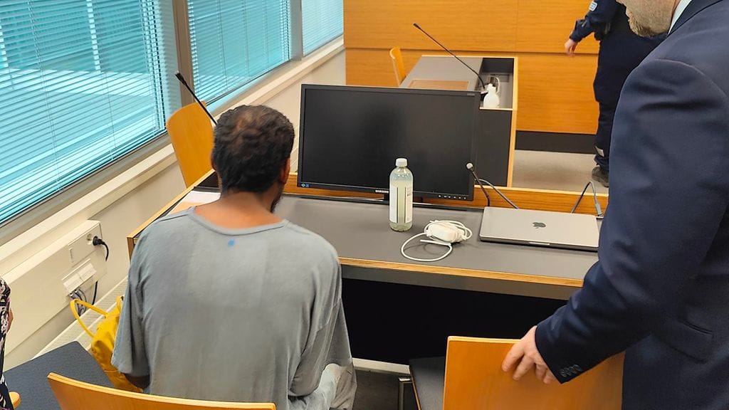 28-vuotias syytetty ei peitellyt kasvojaan saapuessaan Itä-Uudenmaan käräjäoikeuteen. Syytetyn oikealla puolella hänen asianajajansa ja vasemmalla puolellaan tulkki.