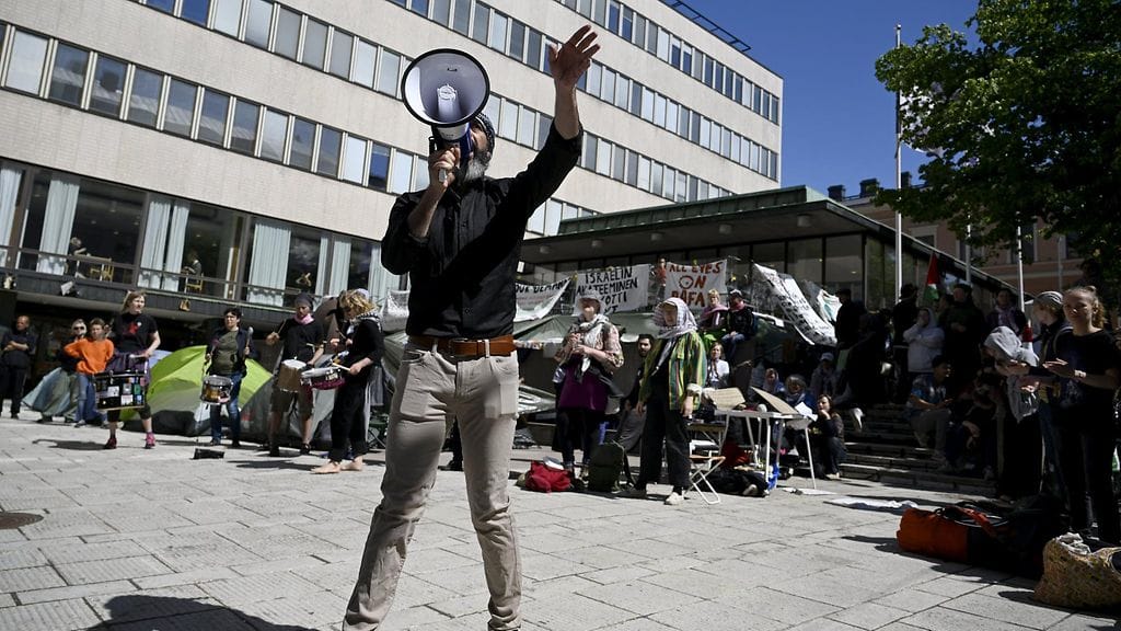 Israelin yliopistojen boikottia vaativat Students for Palestine -liikkeen mielenosoittajia Helsingin yliopiston Porthania-rakennuksen edustalla 12. kesäkuuta.