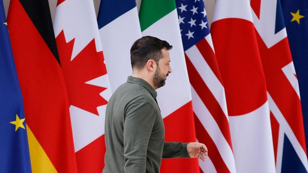Ukrainan presidentti Volodymyr Zelensky kävelee kansallisten lippujen ohi saapuessaan Borgo Egnazian lomakeskukseen Italian isännöimään G7-huippukokoukseen.