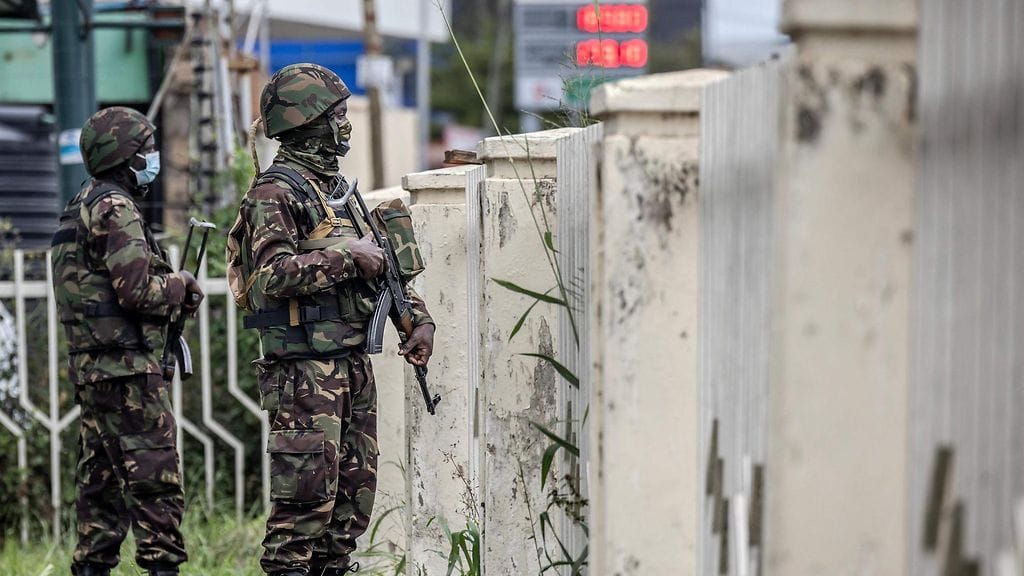 Kenian puolustusvoimien (KDF) sotilaat tarkkailevat aluetta aidan takaa.