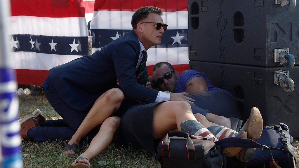 Salaisen palvelun jäsen ja väkijoukon jäseniä republikaanien presidenttiehdokkaan entisen presidentin Donald Trumpin tilaisuudessa.