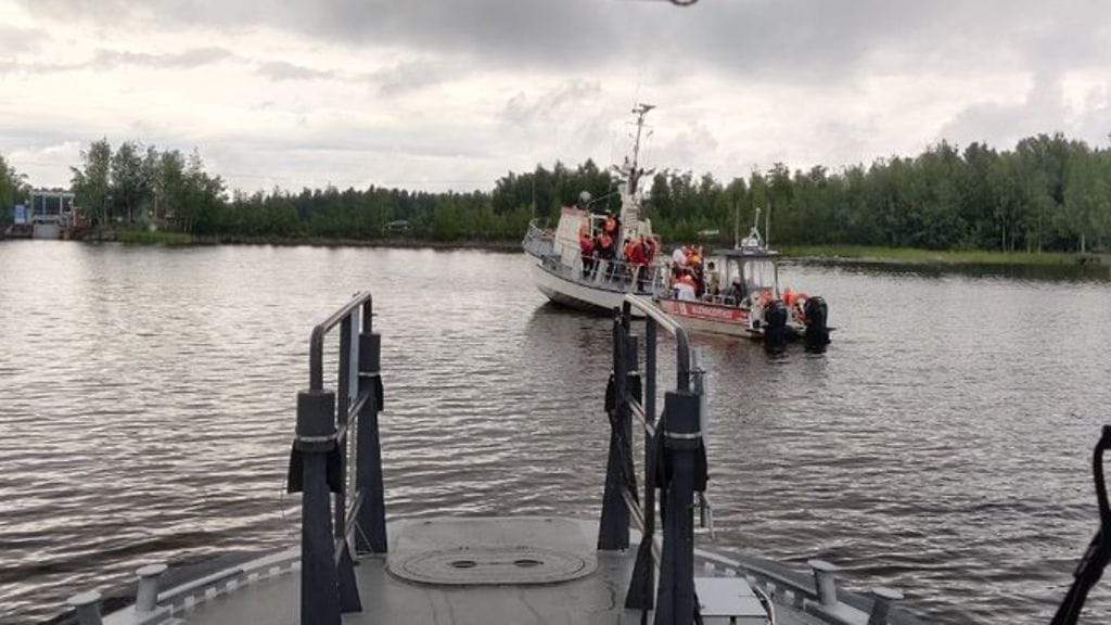 Kuvassa näkyy, miten vesibussin matkustajia evakuoidaan pelastuslaitoksen alukseen.