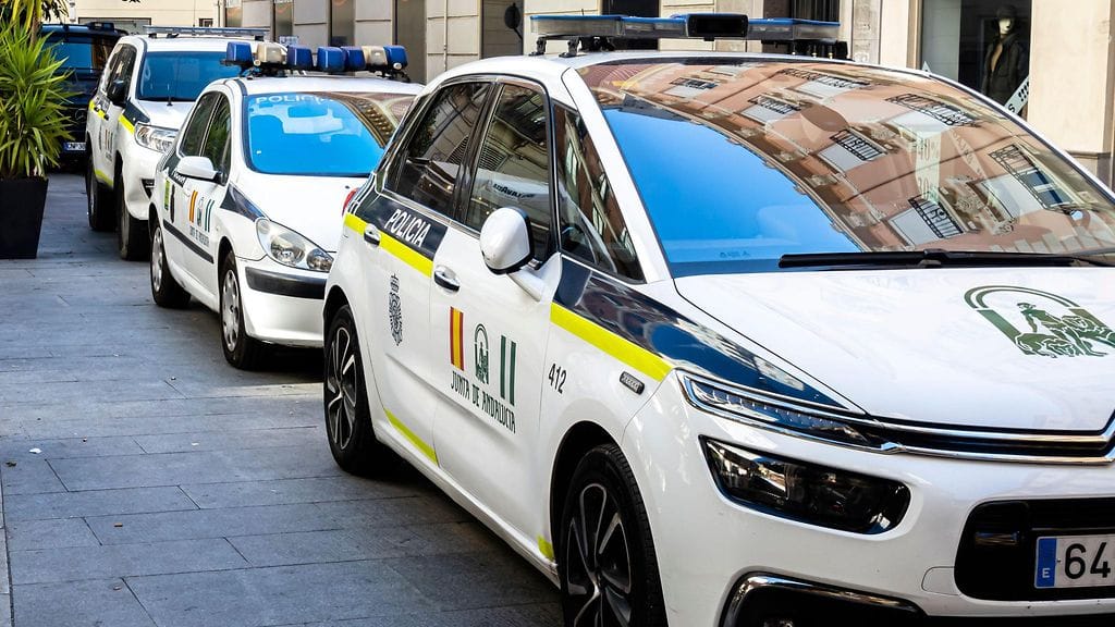 Kuvituskuvassa paikallisen poliisin poliisiautoja peräkkäin Granadan keskustassa Andalusiassa Espanjassa.