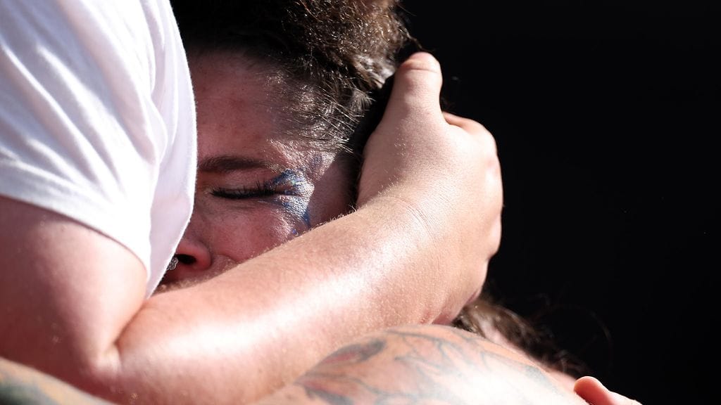 Chase Jackson puolisonsa Mitch Jacksonin syleilyssä olympiapettymyksen varmistuttua.