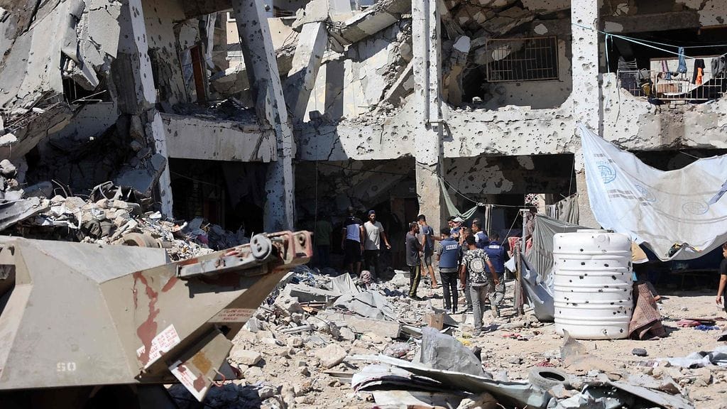 Arkistokuva. Palestiinalaisia tarkastamassa tuhojen jälkiä al-Zahran koulurakennuksen luona Israelin perjantaina tekemän iskun jälkeen.