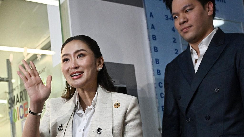 Paetongtarn Shinawatra vilkutti median edustajille Bangkokissa perjantaina seuranaan hänen aviomiehensä Pitaka Suksawat.