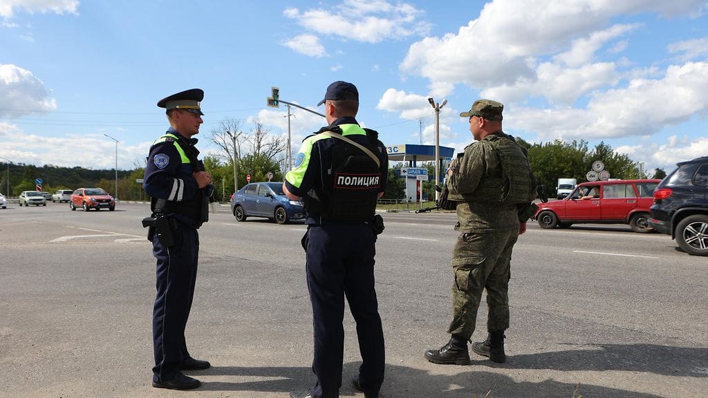 Poliisit ja sotilas vartioimassa tietä Belgorodissa 12. elokuuta.