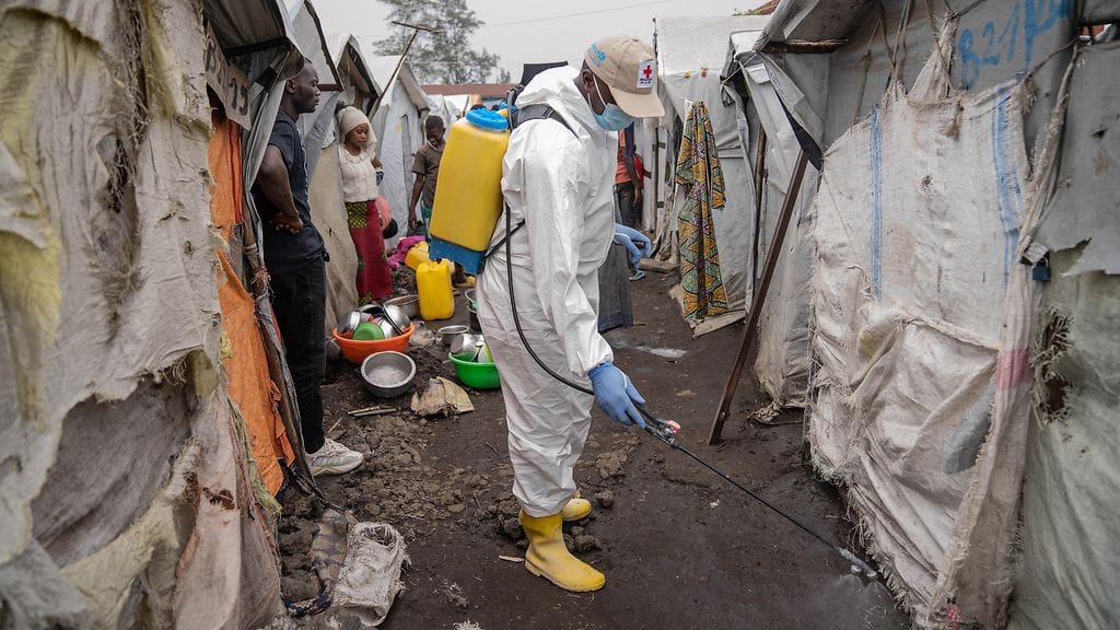 Punaisen ristin työntekijä ruiskutti klooria pakolaisleirillä Kongossa 22. elokuuta.