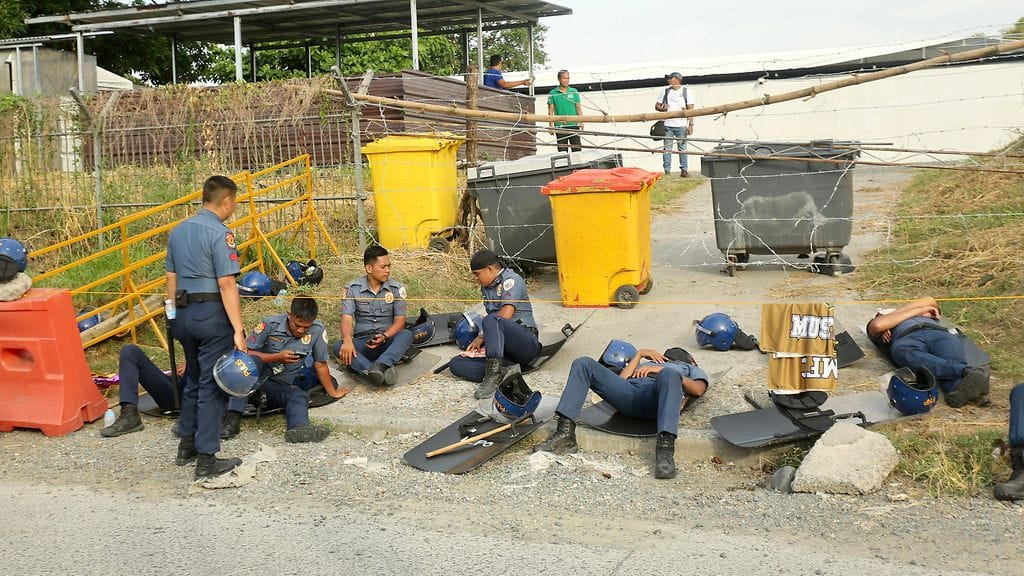 AOP Poliiseja Jeesuksen Kristuksen kuningaskunnan alueen ulkopuolella Davaon kaupungissa Filippiineillä 26. elokuuta 2024. Poliisit ovat pidättämässä KOJC:n johtajaa, pastori Apollo Quiboloytä, joka väittää olevansa Jumalan poika.