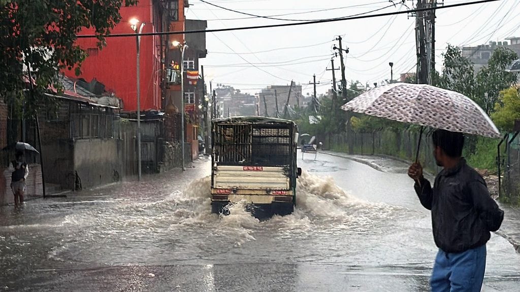 Ajoneuvo kulkee tulvivalla kadulla Kathmandussa.