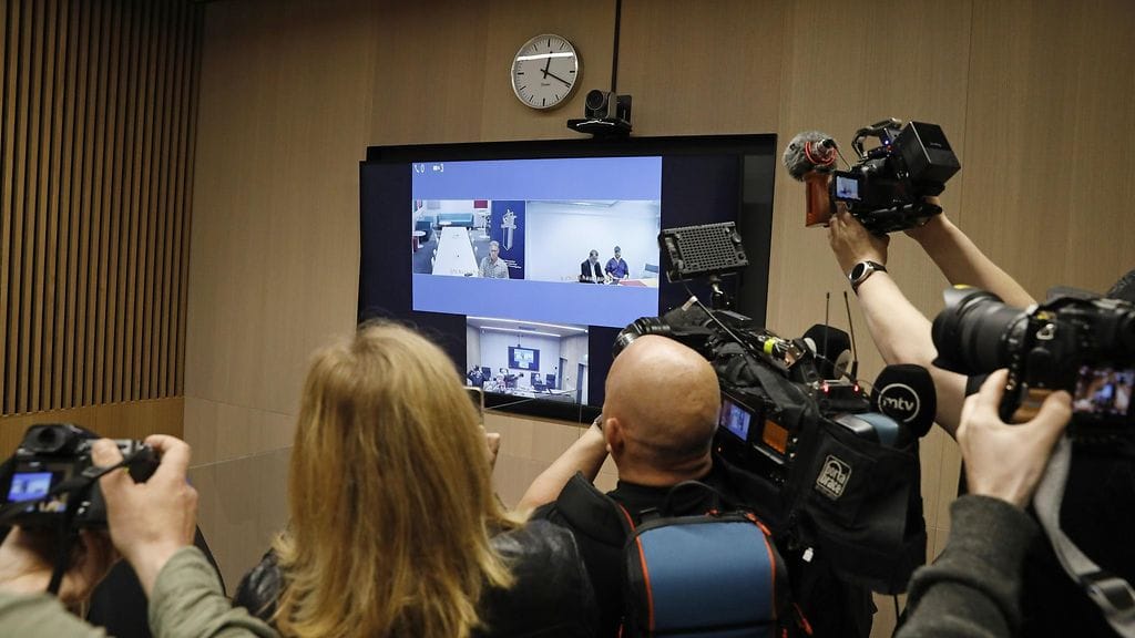 Oulussa kauppakeskus Valkeassa tapahtuneesta 12-vuotiaan lapsen puukotuksesta epäillyn Juhani Sebastian Lämsän (näytöllä oikealla) vangitsemisoikeudenkäynti käytiin etäyhteyksin Oulun käräjäoikeuden 17. kesäkuuta. Etänä paikalla olivat myös tutkinnanjohtaja, rikosylikomisario Ari Soronen (näytöllä vas.) Keskusrikospoliisista ja epäillyn avustajana asianajaja Heikki Aspegren.