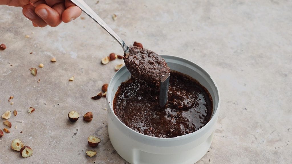 Suklaa-hasselpähkinälevitteen voi ajaa tasaiseksi esimerkiksi sauvasekottimen prosessoriosalla tai sitten tehosekoittimessa.