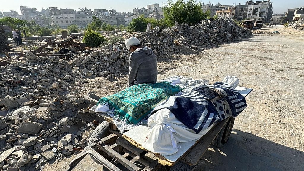 Haavoittunut palestiinalainen lepäsi ruumiinkuljetuskärryn reunalla Beit Lahiassa Gazan pohjoisosassa sunnuntaina.