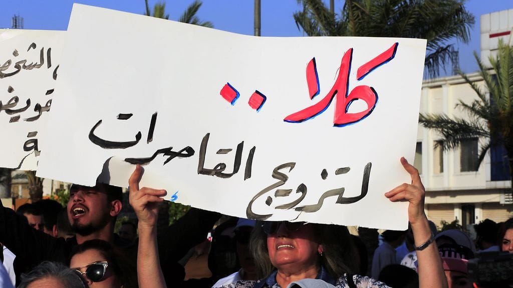 Ihmiset osoittivat elokuussa mieltään kaavailtua lakimuutosta vastaan. Kyltissä lukee arabiaksi "Ei lapsiavioliitoille".