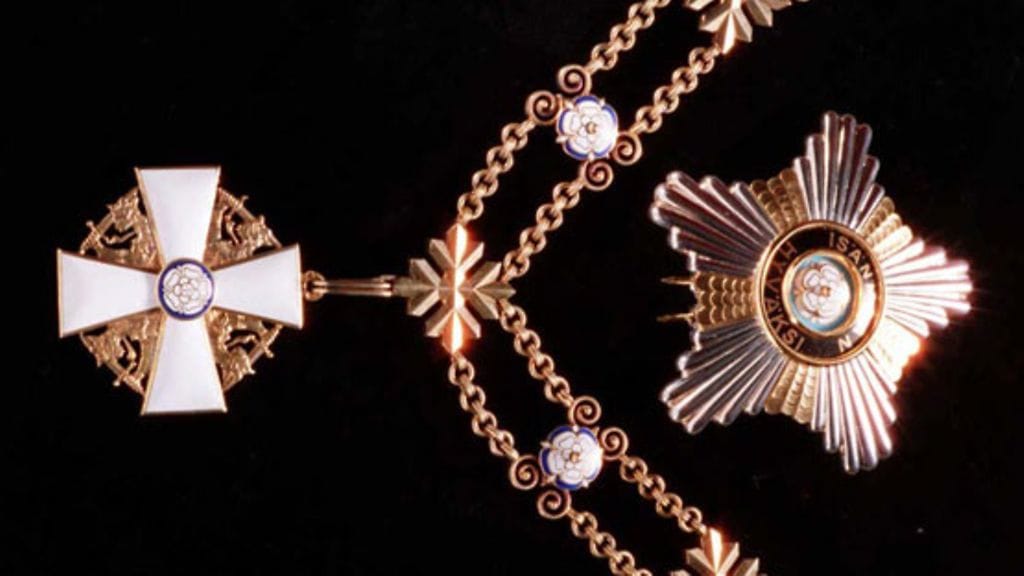 Kuvassa presidentin kantama Suomen Valkoisen Ruusun suurristi ketjuineen, sekä rintatähti.