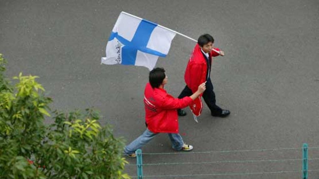 Japanilaiset kantavat Suomen lippua.