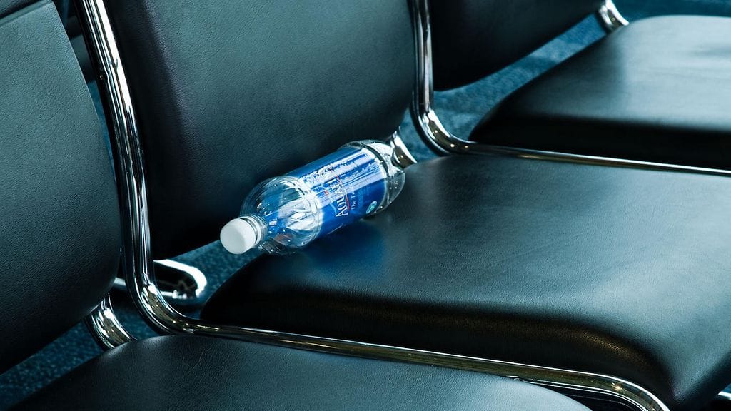 Vesipullon vieminen lentokoneeseen aiheuttaa päänvaivaa. Kuvassa lentokentän penkille hylätty tyhjä pullo.