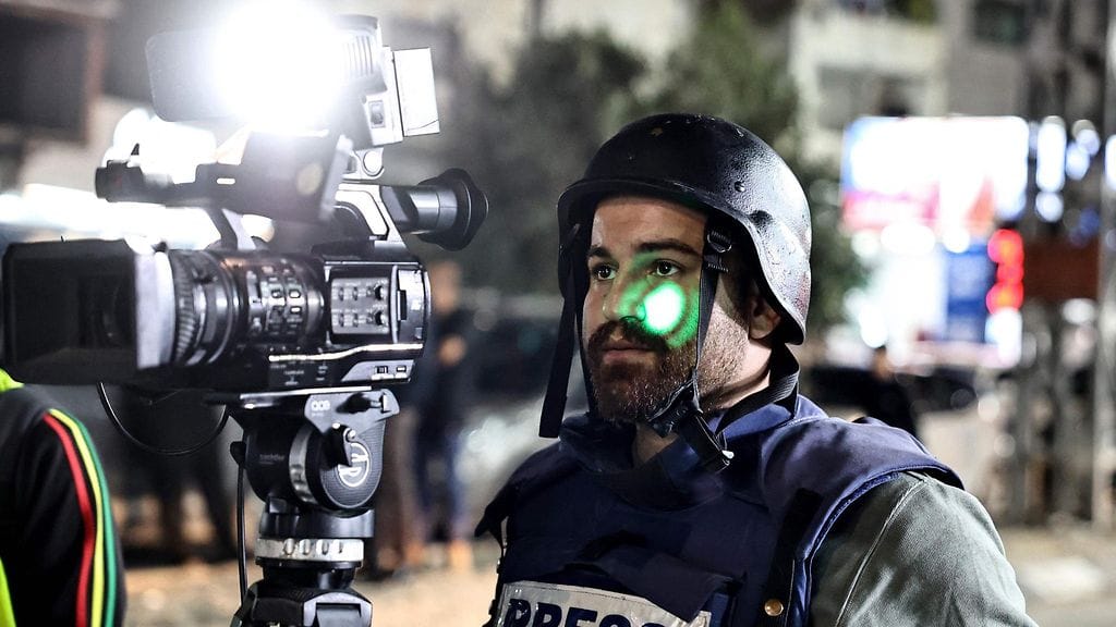 Vihreä laser valaisee toimittajan kasvoja Deir Sharafin tarkastuspisteellä Palestiinan Länsirannalla.