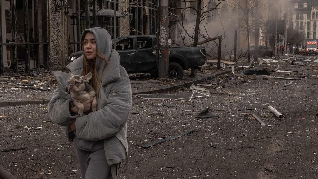 Kuvituskuvassa koiraa kantava nainen ohjushyökkäyksen tapahtumapaikalla Kiovassa tänään perjantaina.