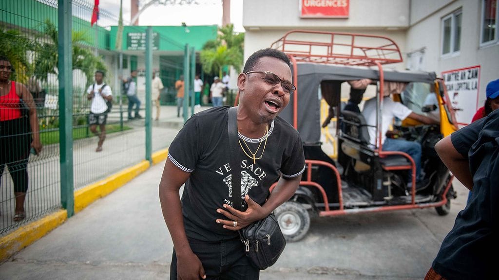 Järkyttynyt toimittaja itki La Paixen sairaalan luona hyökkäyksen jälkeen Haitin pääkaupunki Port-au-Princessä.