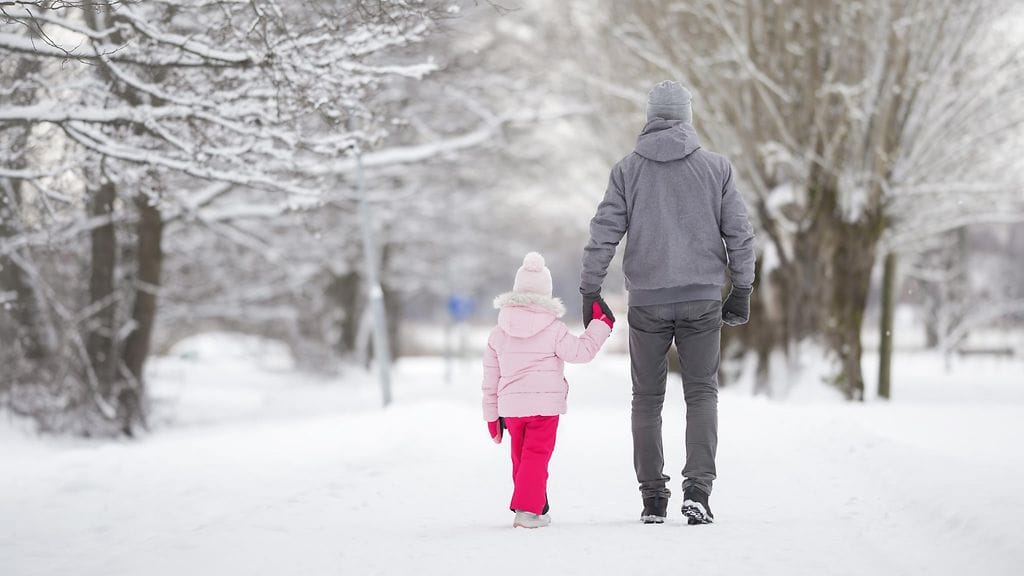 isä ja lapsi kävelevät ulkona talvella