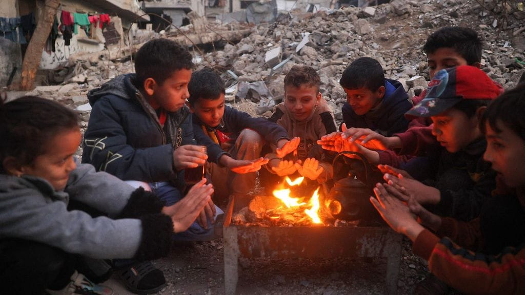 Lapset lämmittelemässä tulen ympärillä Gazassa.