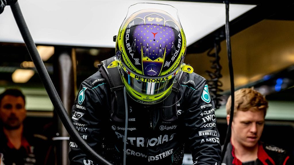 Lewis Hamilton (kuvassa keskellä, kypärä päässä).