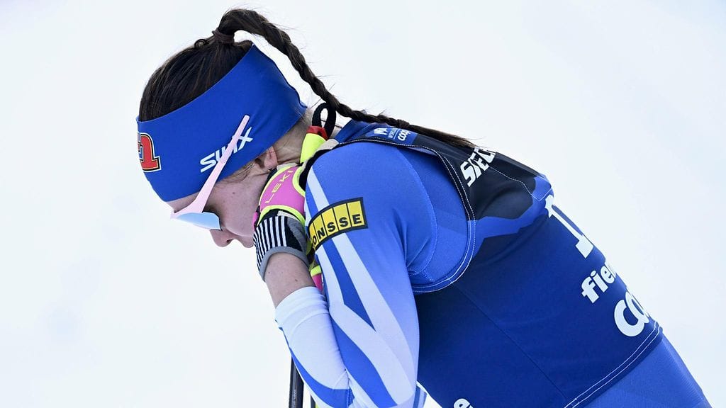 Kerttu Niskanen nojasi alakuloisena suksiinsa puolivälierähiihtonsa jälkeen.
