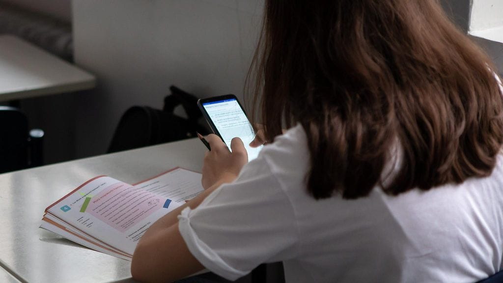 Äidinkielen opiskelua ja matkapuhelimen käyttöä peruskoulussa Helsingissä 30. elokuuta 2019. Kuvituskuva.