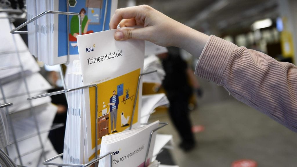 Kuvituskuva. Henkilö katsoo esitteitä Kelan palvelupisteessä Helsingissä 15. kesäkuuta 2020.