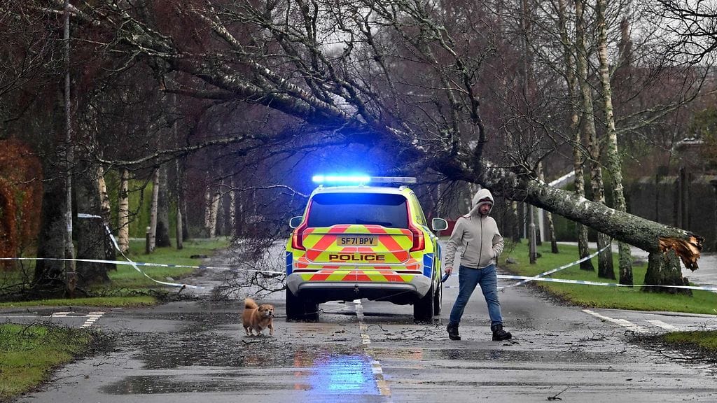 Otsikolla ei viitata tähän kuvaan. Mies käveli koiransa kanssa poliisiauton ja kaatuneen puun ohi Helensburghissa Skotlannissa perjantaina.