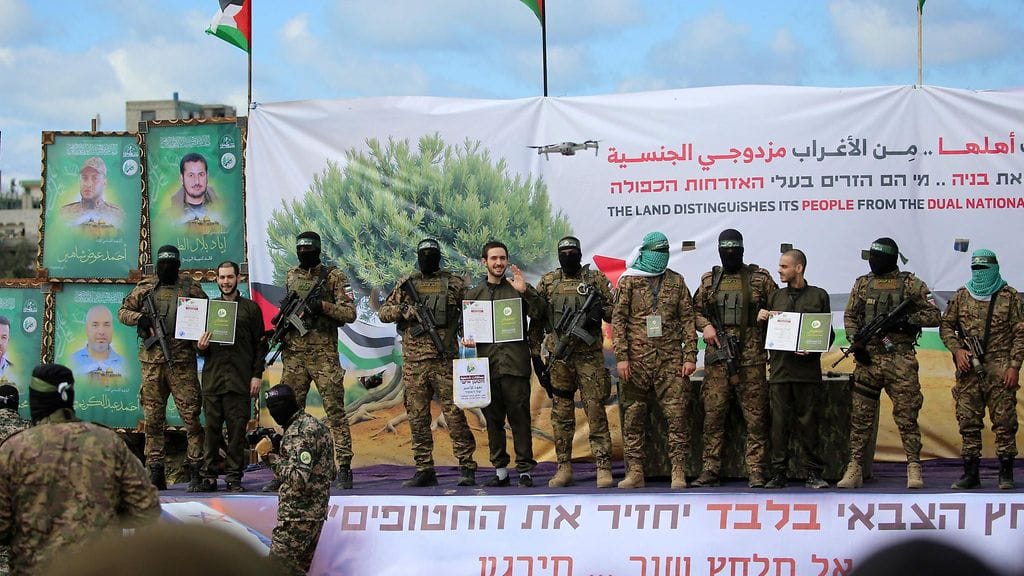 Kolme vapautettua israelilaista panttivankia lavalla Hamasin sotilaiden kanssa.