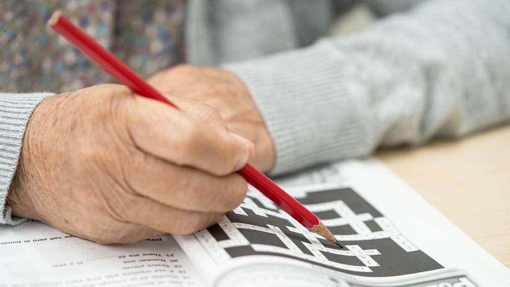 iäkäs ihminen tekee sudokua