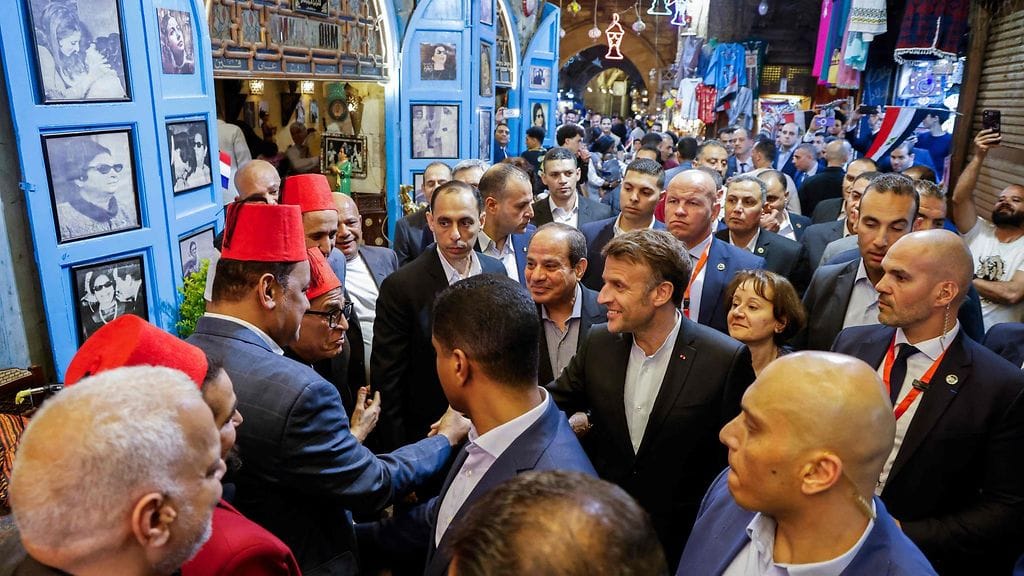Ranskan presidentti Emmanuel Macron ja Egyptin presidentti Abdel Fattah el-Sisi keskustelevat kauppiaiden kanssa Kairon keskustassa.