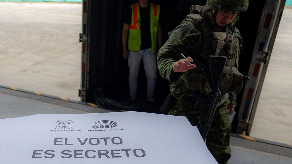 Sotilas seisoi lauantaina vartiossa kansallisen vaalilautakunnan (CNE) jäsenen vieressä Quitossa.