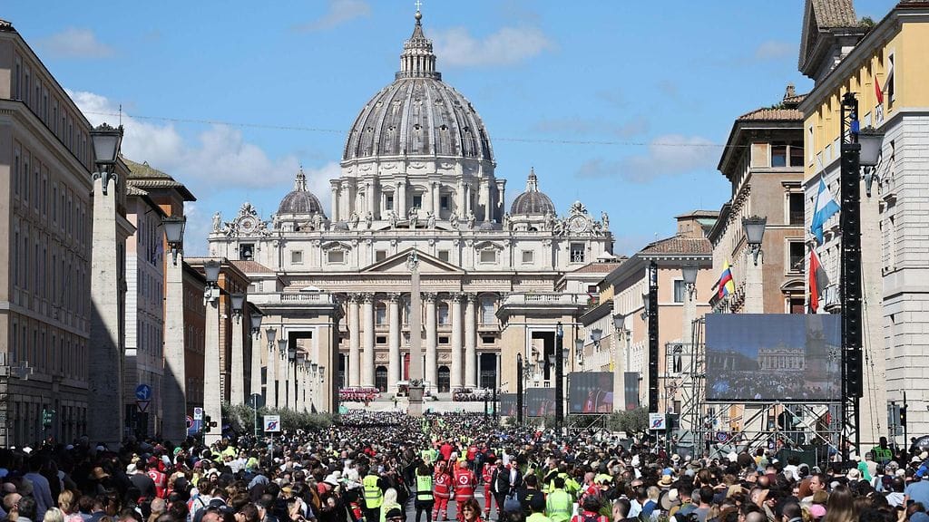Pietarinkirkko kohoaa taustalla, kun hautajaisyleisö on kokoontunut kaduille Vatikaanissa.