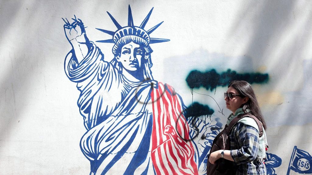 Nainen käveli sunnuntaina Yhdysvaltain vastaisen seinämaalauksen vieressä lähellä USA:n entistä suurlähetystöä Teheranissa Iranissa.